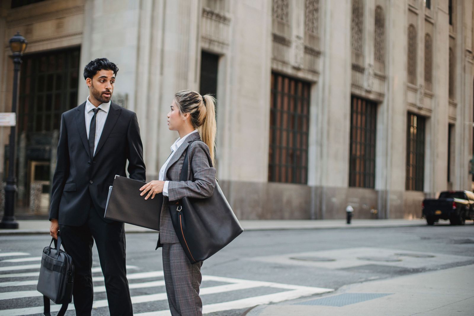 Two financial professionals in conversation outside a financial district building