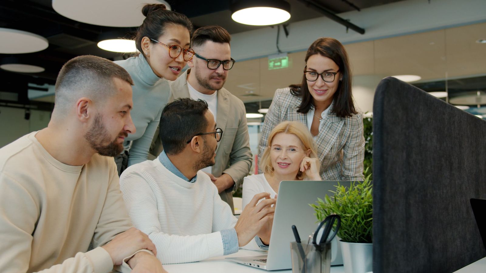 A diverse financial team collaborating around a laptop